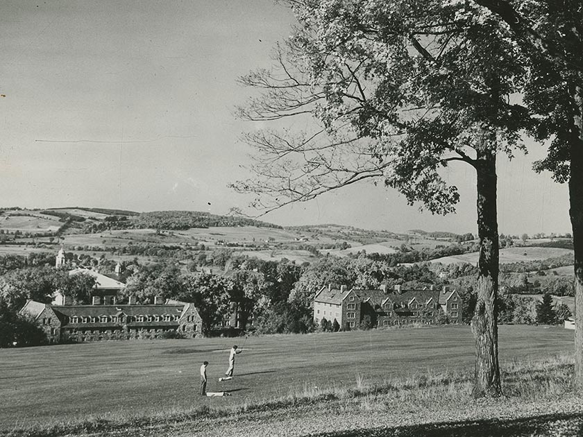 Two golfers on the old golf course, with Andrews and Stillman Halls visible in the background